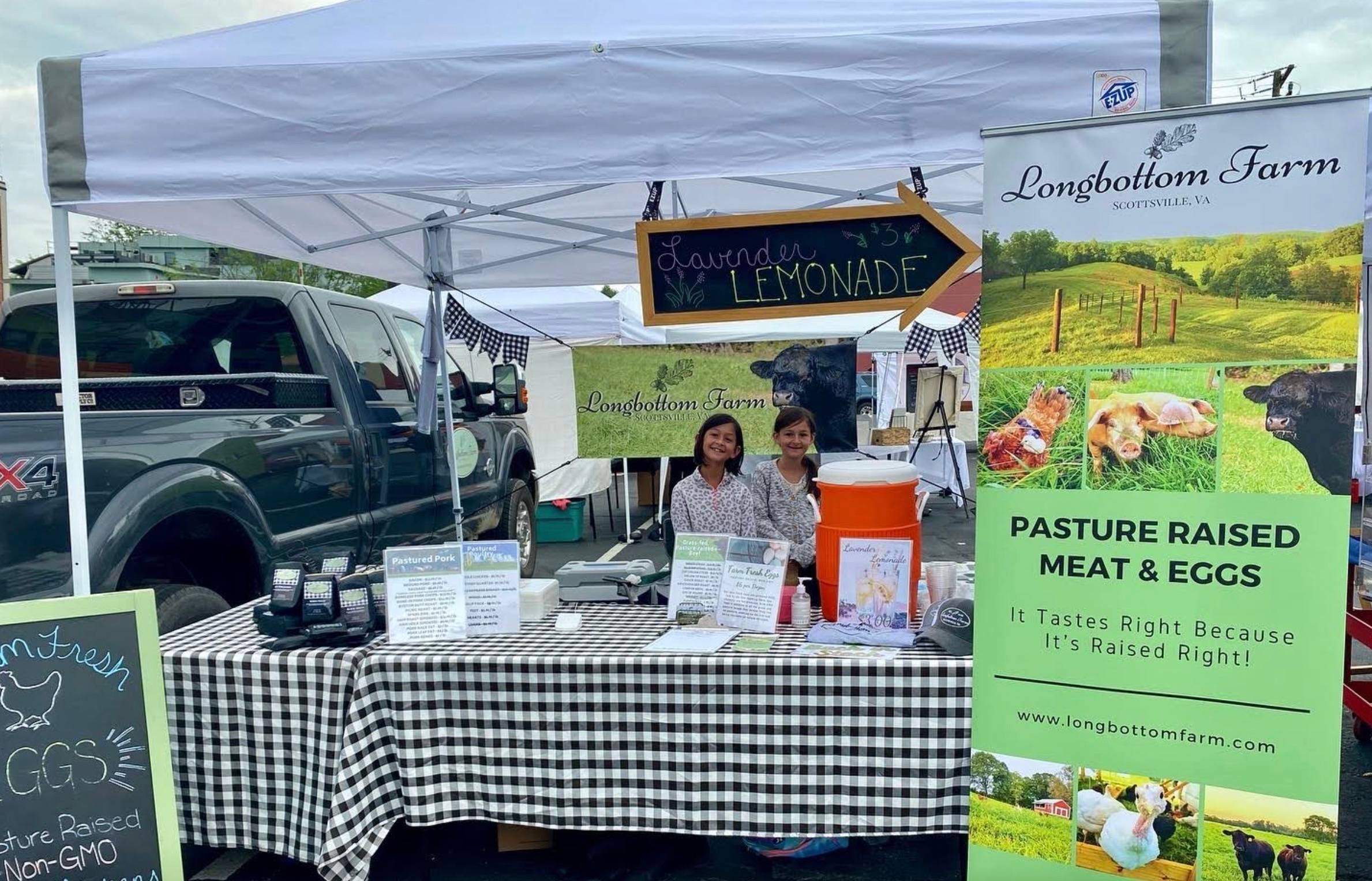 Our daughters tending the farmers market booth for Longbottom Farm